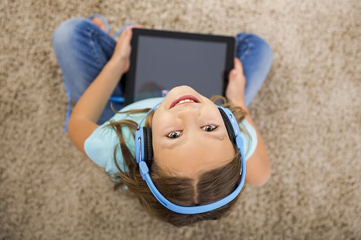 Girl on Ipad with Headphones Looking Up