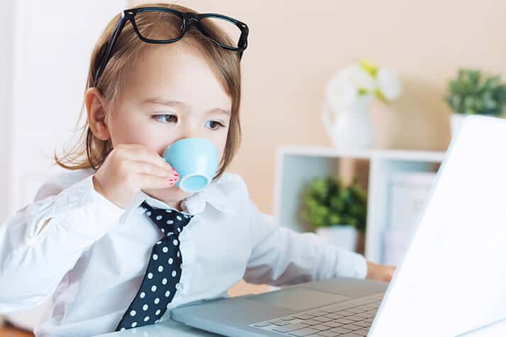 Smart Kid Drinking Morning Tea in Tie on the Laptop Checking Portfolio